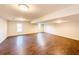 Spacious basement with wood-look tile flooring, recessed lighting, and natural light from two windows at 110 Randomwood Way, Alpharetta, GA 30022