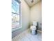 Small bathroom features a sleek toilet and a window view, complemented by marble-look tile flooring at 110 Randomwood Way, Alpharetta, GA 30022
