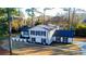 View of a bright, updated home with dark shutters, large yard and a brick privacy fence at 110 Randomwood Way, Alpharetta, GA 30022