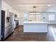 Bright kitchen features stainless steel appliances, an island with white countertops and dark wood floors at 110 Randomwood Way, Alpharetta, GA 30022