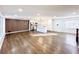 Open-concept living room with wood floors, modern lighting, and stainless steel appliances at 110 Randomwood Way, Alpharetta, GA 30022