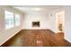 Bright living room with a white brick fireplace, wood flooring, and ample natural light at 110 Randomwood Way, Alpharetta, GA 30022