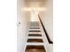 Wooden staircase with white risers and a handrail, leading to the upper level of the house at 110 Randomwood Way, Alpharetta, GA 30022