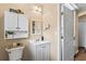 Bathroom with white vanity, a toilet with a wooden tray, and overhead cabinet at 1751 Thomasville Se Dr, Atlanta, GA 30315