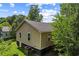 Exterior side view showing the tan siding, dark roof, green lawn and mature trees at 1751 Thomasville Se Dr, Atlanta, GA 30315