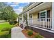Inviting front porch with white railing, brown steps and manicured landscaping at 1751 Thomasville Se Dr, Atlanta, GA 30315