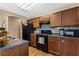 Kitchen featuring wood cabinets, tile backsplash, and black appliances at 1751 Thomasville Se Dr, Atlanta, GA 30315
