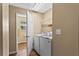 Bright laundry room with white washer and dryer, shelving and wood-look floor at 1751 Thomasville Se Dr, Atlanta, GA 30315