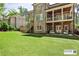 Lush backyard featuring a well-maintained lawn and an elegant brick house with a covered patio and deck at 156 Lake Forrest Ne Ln, Atlanta, GA 30342