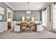 Stylish dining room featuring a rustic wooden table, modern chandelier, and white chairs at 156 Lake Forrest Ne Ln, Atlanta, GA 30342