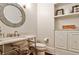 Stylish half bathroom with unique mirror, marble countertop, and basket for storage at 156 Lake Forrest Ne Ln, Atlanta, GA 30342