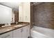 Bathroom with granite counters, white cabinets, tub, and tiled shower, exuding elegance and functionality at 270 17Th Nw St # 2210, Atlanta, GA 30363