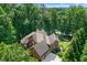 Aerial view of a brick home surrounded by lush greenery and a lake view at 5765 Riley Rd, Cumming, GA 30028