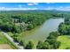 Expansive lakefront views surround this gorgeous property, with the lush green forest as a backdrop at 5765 Riley Rd, Cumming, GA 30028