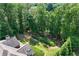 Aerial view of landscaped backyard leading to a firepit near the lake at 5765 Riley Rd, Cumming, GA 30028