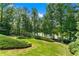Beautiful backyard with manicured lawn, lush landscaping, and lake view at 5765 Riley Rd, Cumming, GA 30028