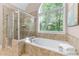 Bathroom with glass shower, soaking tub, and a large window at 5765 Riley Rd, Cumming, GA 30028
