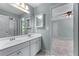 Bathroom featuring a double sink vanity, large mirror, and a view into the carpeted bedroom at 5765 Riley Rd, Cumming, GA 30028