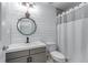 Charming bathroom with modern fixtures, shiplap walls, round mirror, and neutral color palette at 5765 Riley Rd, Cumming, GA 30028
