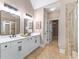 Bathroom with double vanity, framed mirrors, and walk-in closet access at 5765 Riley Rd, Cumming, GA 30028
