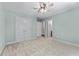 Bright bedroom with plush carpeting, a ceiling fan, and ensuite bath and closet access at 5765 Riley Rd, Cumming, GA 30028