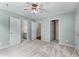 Light-filled bedroom featuring ceiling fan, neutral carpeting, and ensuite bath and closet access at 5765 Riley Rd, Cumming, GA 30028