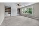 Bonus room with built-in shelving, carpet, and large window overlooking the wooded backyard at 5765 Riley Rd, Cumming, GA 30028