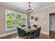 Bright dining area with a wooden table, seating for four, and a large window overlooking lush greenery at 5765 Riley Rd, Cumming, GA 30028