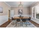 Formal dining room with wainscoting, hardwood floors, modern chandelier, and ample natural light at 5765 Riley Rd, Cumming, GA 30028