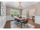 Elegant dining room featuring hardwood floors, wainscoting, a modern chandelier, and large windows at 5765 Riley Rd, Cumming, GA 30028