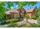 Stately brick home with lush landscaping, paver driveway, and mature trees providing shade and privacy at 5765 Riley Rd, Cumming, GA 30028