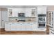 Close up of the gourmet kitchen featuring stainless steel appliances and sleek, white cabinetry at 5765 Riley Rd, Cumming, GA 30028