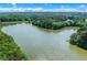 Expansive lake surrounded by lush green forest with blue sky and white, fluffy clouds at 5765 Riley Rd, Cumming, GA 30028