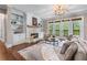 Cozy living room with a fireplace, built-in shelves, hardwood floors, and views to the exterior at 5765 Riley Rd, Cumming, GA 30028