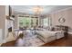 Bright living room featuring a stone fireplace, hardwood floors, and elegant lighting fixture at 5765 Riley Rd, Cumming, GA 30028