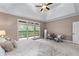 Large primary bedroom, featuring plush carpeting and a balcony with scenic views at 5765 Riley Rd, Cumming, GA 30028
