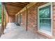 Covered brick patio with wood ceiling overlooks the backyard with view of the lake at 5765 Riley Rd, Cumming, GA 30028