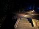 Well-lit wooden walkway featuring landscape lighting that adds safety and elegance to the outdoor space at 5765 Riley Rd, Cumming, GA 30028