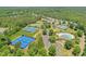Aerial view showcases a community with tennis courts and swimming pool nestled among lush greenery, offering a serene lifestyle at 935 Santa Anita Dr, Woodstock, GA 30189