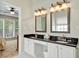 Bathroom features a double granite vanity, white cabinetry and framed mirrors at 935 Santa Anita Dr, Woodstock, GA 30189