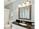 This bathroom features a granite vanity, white cabinets, and decorative framed mirror at 935 Santa Anita Dr, Woodstock, GA 30189