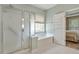 Bright bathroom featuring a tub, glass shower and window at 935 Santa Anita Dr, Woodstock, GA 30189