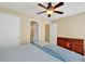 This bedroom features neutral walls, white doors, wood dresser, and ceiling fan at 935 Santa Anita Dr, Woodstock, GA 30189