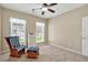 Bright bedroom featuring neutral walls, a rocking chair, and natural light through large windows at 935 Santa Anita Dr, Woodstock, GA 30189