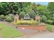 Landscaped community entrance sign with manicured bushes and brick pillars at 935 Santa Anita Dr, Woodstock, GA 30189