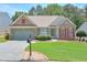 Charming single-story home with a well-manicured lawn and brick exterior, enhancing curb appeal at 935 Santa Anita Dr, Woodstock, GA 30189