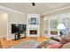 Living room featuring hardwood floors, a fireplace, a ceiling fan, and natural light through windows at 935 Santa Anita Dr, Woodstock, GA 30189