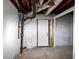 Unfinished basement with concrete floor, exposed ductwork, and white painted walls and door at 2480 Miriam Ln, Decatur, GA 30032
