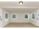 Large open basement room with three windows, two doors, and neutral paint color at 2480 Miriam Ln, Decatur, GA 30032