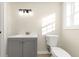 Bathroom featuring a modern vanity, new lighting fixtures, toilet, and a window for natural light at 2480 Miriam Ln, Decatur, GA 30032